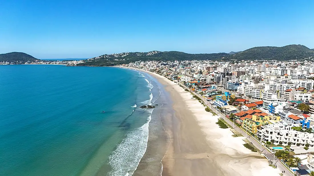 Praia urbana de Bombinhas com prédios à beira-mar